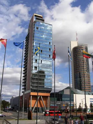 a tall glass building with flags in front of it at Europa Dream Apartment in Vilnius