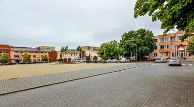 a city street with cars parked in a parking lot at Guest House Simona in Lazdijai