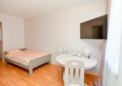 a white room with a table and a bed and a table and a table at Guest House Simona in Lazdijai