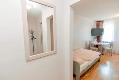 a bedroom with a mirror and a bed and a table at Guest House Simona in Lazdijai