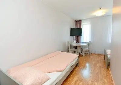 a bedroom with a bed and a table in it at Guest House Simona in Lazdijai