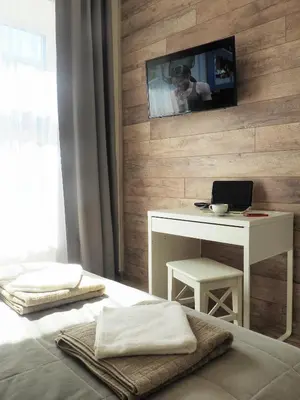 a bedroom with a desk and a table with a laptop at Emi apartment in Vilnius