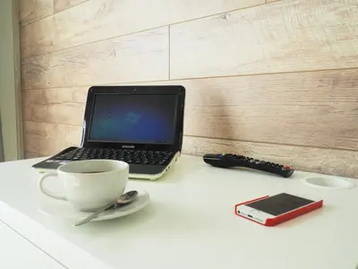 a laptop computer sitting on a table with a cup of coffee at Emi apartment in Vilnius