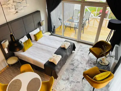 a bedroom with a bed and a balcony with a table and chairs at Duarto house, Sauna and Hot Tub in Šiaudinė