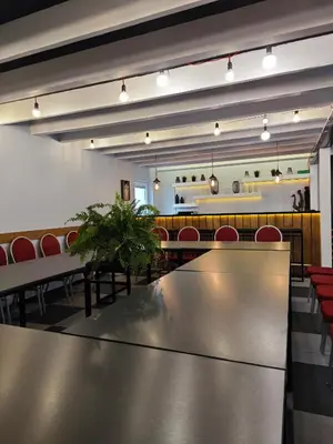 a conference room with a table and red chairs at Duarto house, Sauna and Hot Tub in Šiaudinė