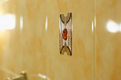 a metal switch on a wall in a bathroom at Cozy Apartment in Gothic style house in the Heart of the Old Town in Vilnius