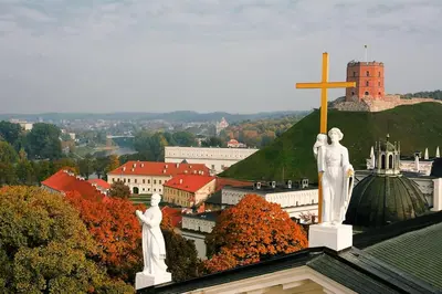 two statues on top of a building with a cross at Cozy Apartment in Gothic style house in the Heart of the Old Town in Vilnius
