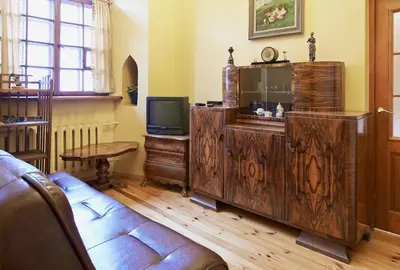 a living room with a couch and a television at Cozy Apartment in Gothic style house in the Heart of the Old Town in Vilnius