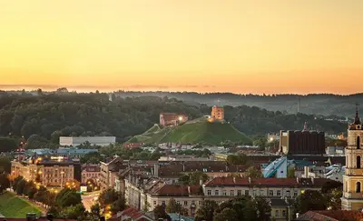 a cityscape of a city at sunset at Luxury Panoramic Vilnius apartment in Vilnius