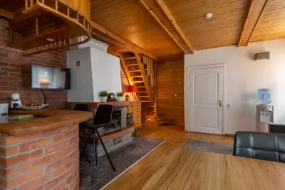 a living room with a brick fireplace and wooden ceilings at Slėnis Trakuose in Trakai