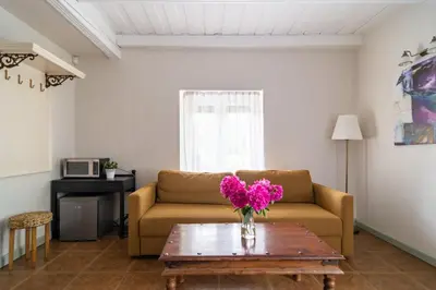 a living room with a couch and a table with purple flowers at Slėnis Trakuose in Trakai