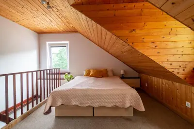 a bedroom with a bed with a wooden ceiling at Slėnis Trakuose in Trakai