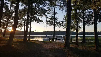 a boat is docked on the shore of a lake at Slėnis Trakuose in Trakai