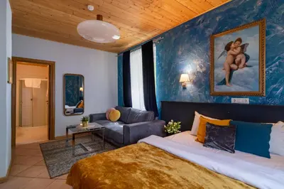 a bedroom with a king sized bed and a couch at Slėnis Trakuose in Trakai