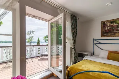 a bedroom with a bed and a balcony at Slėnis Trakuose in Trakai