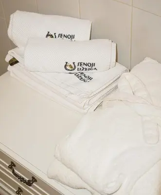 a pile of white towels sitting on top of a shelf at Senoji užeiga in Molėtai