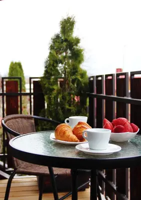 a table with two cups and croissants and fruit on it at Senoji užeiga in Molėtai