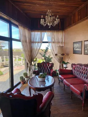 a living room with red furniture and a chandelier at Senoji užeiga in Molėtai