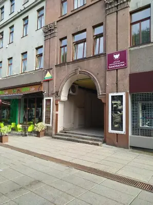 a building with an archway on a city street at Hostel Lux in Kaunas
