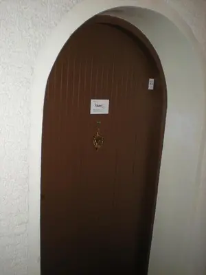 an archway with a brown door with a sign on it at Hostel Lux in Kaunas