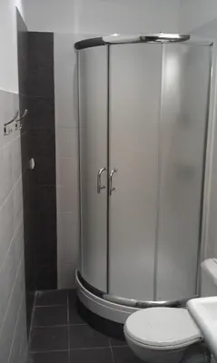 a shower stall in a bathroom with a toilet at Hostel Lux in Kaunas