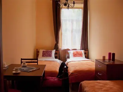 a room with two beds and a table and a window at Hostel Lux in Kaunas