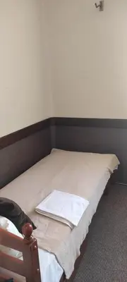 a bed with a white towel on top of it at Hostel Lux in Kaunas
