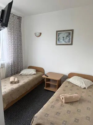 a hotel room with two beds and a table at Turnė Guest House in Šiauliai