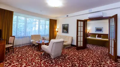 a hotel room with a living room and a bedroom at Hotel Violeta in Druskininkai