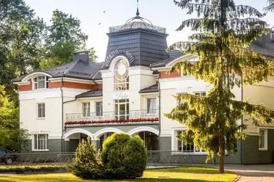 a large building with a clock tower on top of it at Hotel Violeta in Druskininkai