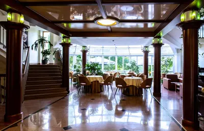 a restaurant with tables and chairs in a building at Hotel Violeta in Druskininkai