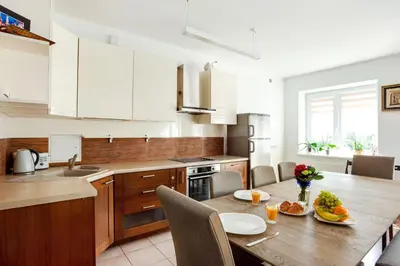 a kitchen with a wooden table and a dining room at #inVilnius - Spacious & Bright 1BDR Apartment Shopping District in Vilnius