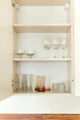 a cupboard with wine glasses and other dishes at #inVilnius - Spacious & Bright 1BDR Apartment Shopping District in Vilnius