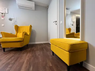 a waiting room with yellow chairs and a mirror at Stay Vilnius Hotel in Vilnius