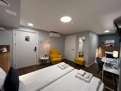 a hotel room with two beds and a table and chairs at Stay Vilnius Hotel in Vilnius