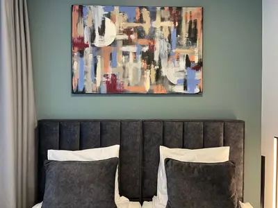 a painting above a bed with two pillows at Stay Vilnius Hotel in Vilnius