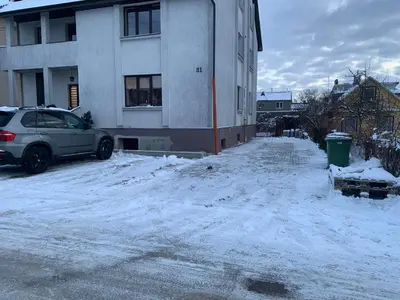 a car parked in front of a building in the snow at Sauliaus apartamentai in Panevėžys