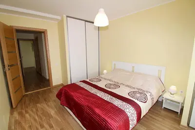 a bedroom with a bed with a red blanket at Sauliaus apartamentai in Panevėžys