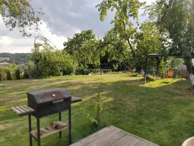 a barbecue grill in a yard with a park at Hillside view house with garden, private parking, quiet location - 12 min to Old town anytime, Long stays welcome in Vilnius