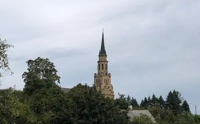a tall tower with a steeple on top of trees at Hillside view house with garden, private parking, quiet location - 12 min to Old town anytime, Long stays welcome in Vilnius