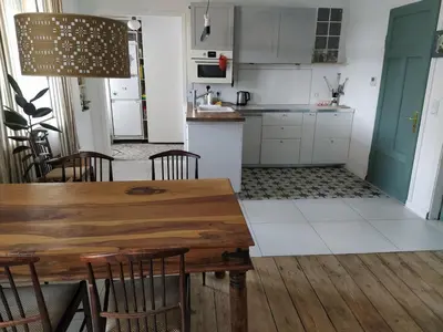 a kitchen and dining room with a wooden table and chairs at Hillside view house with garden, private parking, quiet location - 12 min to Old town anytime, Long stays welcome in Vilnius