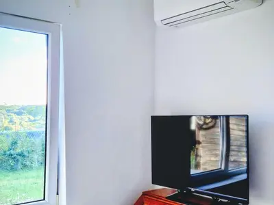 a flat screen tv sitting next to a window at Hillside view house with garden, private parking, quiet location - 12 min to Old town anytime, Long stays welcome in Vilnius