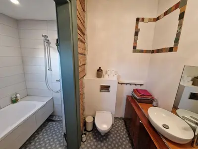 a bathroom with a sink and a toilet and a tub at Hillside view house with garden, private parking, quiet location - 12 min to Old town anytime, Long stays welcome in Vilnius