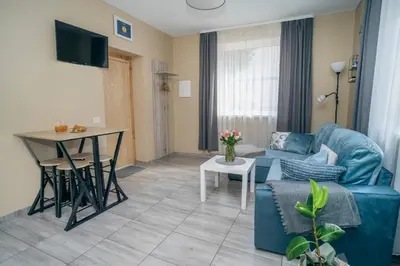 a living room with a blue couch and a table at Cozy Stay Apartment in Kaunas