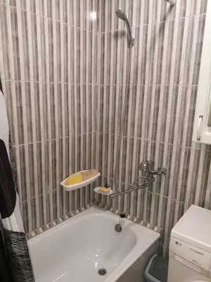 a small bathroom with a tub and a sink at Tėjos guest house in Šiauliai