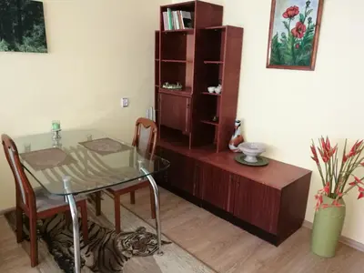 a dining room with a glass table and a book shelf at Tėjos guest house in Šiauliai