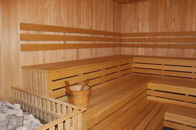 a sauna with a trash can and a bucket in it at Ignalinos sporto ir pramogų centras in Ignalina