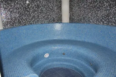 a blue tub in a bathroom with a tile floor at Ignalinos sporto ir pramogų centras in Ignalina