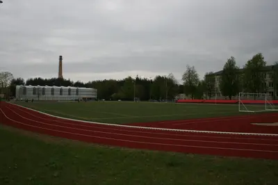 a soccer field with a building in the background at Ignalinos sporto ir pramogų centras in Ignalina