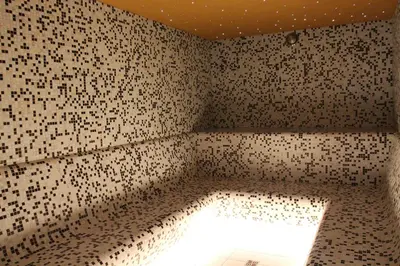 a bathroom with a wall covered in black and white tiles at Ignalinos sporto ir pramogų centras in Ignalina